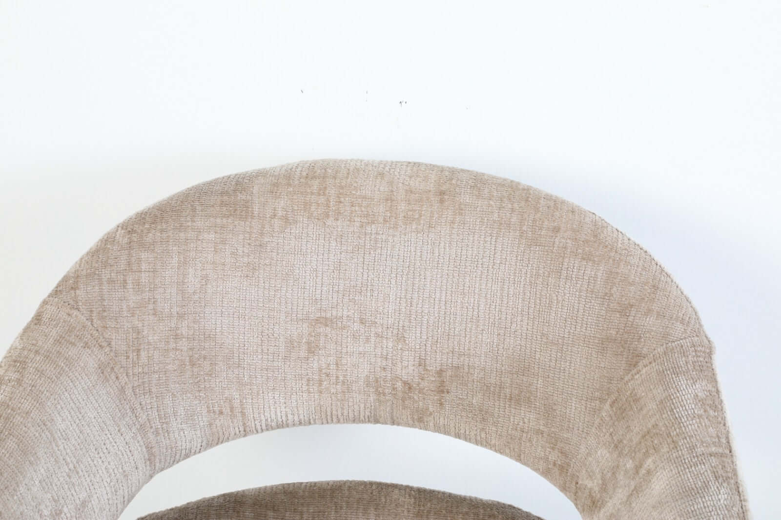 Detail of Elena dining chair by VSO Design, showcasing its soft, textured fabric and elegant open back design.