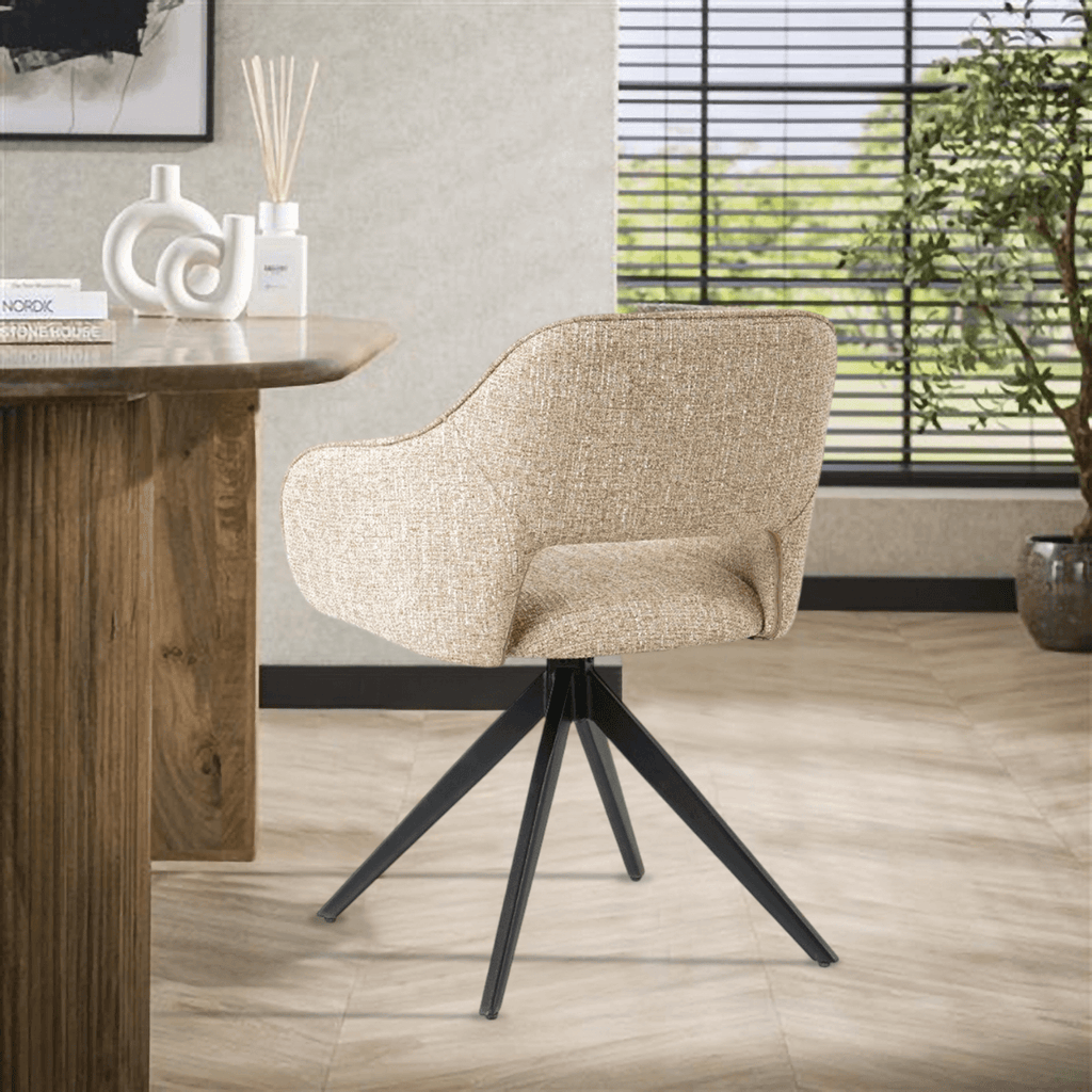 Eetkamerstoel Jordan van VSO Design, met moderne stijl en comfortabel geweven stoffering, geplaatst naast een houten tafel.