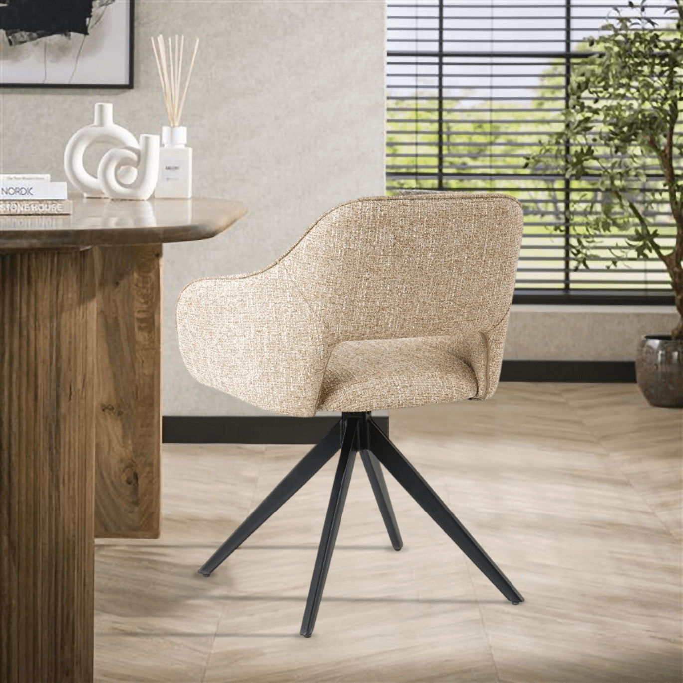 Eetkamerstoel Jordan van VSO Design, met moderne stijl en comfortabel geweven stoffering, geplaatst naast een houten tafel.