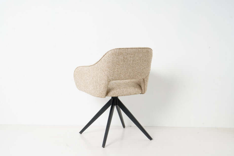 De Jordan eetkamerstoel van VSO Design straalt
moderne elegantie en comfort uit. Dankzij de zachte, geweven stoffering en de
subtiel afgeronde zitting en rugleuning zit je niet alleen stijlvol, maar ook
verrassend comfortabel. Het open detail aan de onderzijde van de rugleuning
geeft de stoel een luchtige, eigentijdse uitstraling.

De Jordan is afgewerkt met een stevige bies rondom de
rug- en armleuningen voor een verfijnde look. Het zwarte metalen onderstel met
slanke, uitlopende poten zorgt voor een stabi
