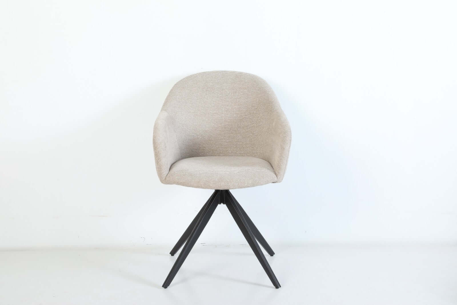 De Maxim eetkamerstoel van VSO Design combineert minimalistische elegantie met optimaal zitcomfort. De zachte, neutraal gekleurde stoffering sluit naadloos aan bij diverse interieurstijlen, van Scandinavisch tot modern industrieel. De volledig gesloten kuipvorm met geïntegreerde armleuningen zorgt voor een comfortabele en ondersteunende zitervaring.

Het robuuste zwarte metalen onderstel met vier taps toelopende poten in kruisvorm geeft de Maxim een stabiele basis en een subtiele design-touch.
