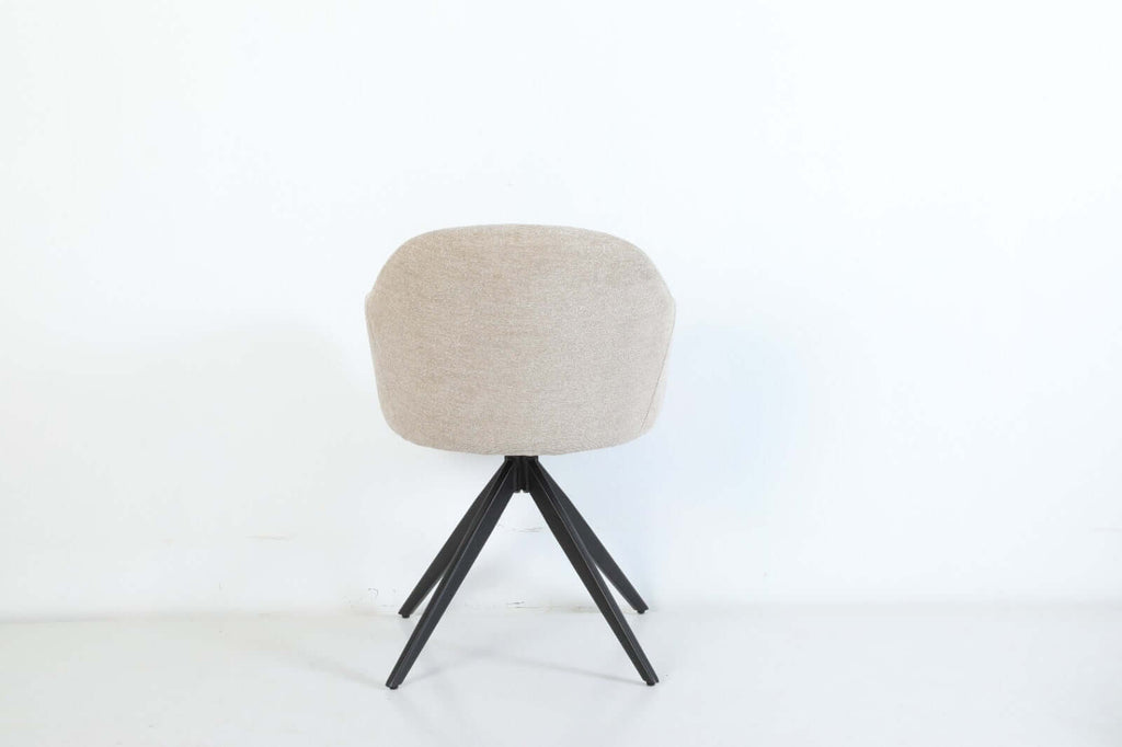 De Maxim eetkamerstoel van VSO Design combineert minimalistische elegantie met optimaal zitcomfort. De zachte, neutraal gekleurde stoffering sluit naadloos aan bij diverse interieurstijlen, van Scandinavisch tot modern industrieel. De volledig gesloten kuipvorm met geïntegreerde armleuningen zorgt voor een comfortabele en ondersteunende zitervaring.

Het robuuste zwarte metalen onderstel met vier taps toelopende poten in kruisvorm geeft de Maxim een stabiele basis en een subtiele design-touch.