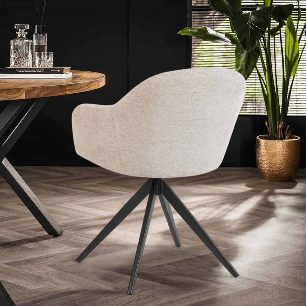 De Maxim eetkamerstoel van VSO Design combineert minimalistische elegantie met optimaal zitcomfort. De zachte, neutraal gekleurde stoffering sluit naadloos aan bij diverse interieurstijlen, van Scandinavisch tot modern industrieel. De volledig gesloten kuipvorm met geïntegreerde armleuningen zorgt voor een comfortabele en ondersteunende zitervaring.

Het robuuste zwarte metalen onderstel met vier taps toelopende poten in kruisvorm geeft de Maxim een stabiele basis en een subtiele design-touch.