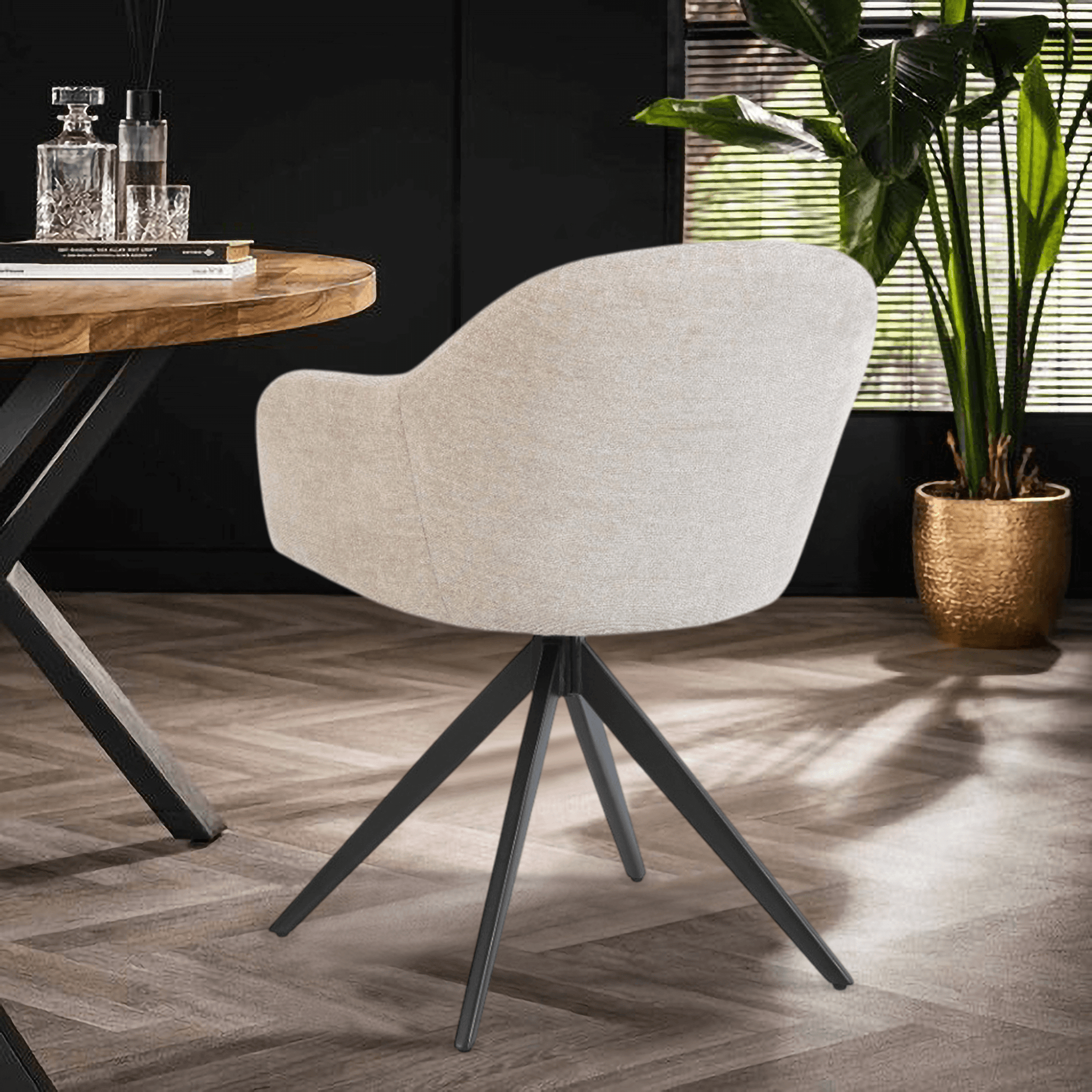 De Maxim eetkamerstoel van VSO Design combineert minimalistische elegantie met optimaal zitcomfort. De zachte, neutraal gekleurde stoffering sluit naadloos aan bij diverse interieurstijlen, van Scandinavisch tot modern industrieel. De volledig gesloten kuipvorm met geïntegreerde armleuningen zorgt voor een comfortabele en ondersteunende zitervaring.

Het robuuste zwarte metalen onderstel met vier taps toelopende poten in kruisvorm geeft de Maxim een stabiele basis en een subtiele design-touch.