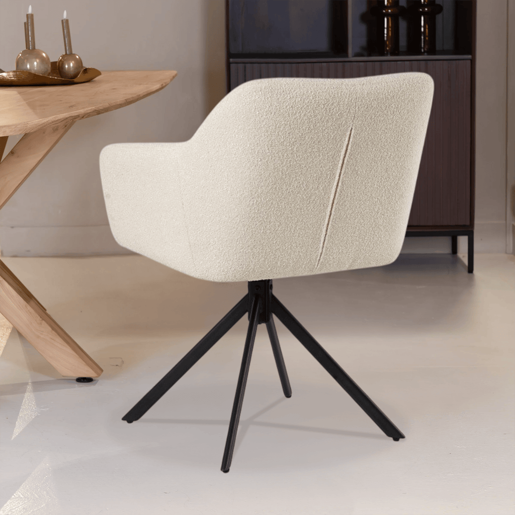 De Rosalie eetkamerstoel van VSO Design is een
perfecte mix van modern design en comfort. De stoel is bekleed met een zachte,
wollige bouclé stof in een elegante witte kleur, wat zorgt voor een warme en
stijlvolle uitstraling in elke eethoek.

Het licht afgeronde design van de rug- en armleuningen biedt
fijne ondersteuning, terwijl de subtiele stiknaden zorgen voor een luxe
afwerking. De zwarte, metalen kruispoot voegt een stoer, industrieel contrast
toe en maakt de stoel stevig én visueel aantrekkelijk.